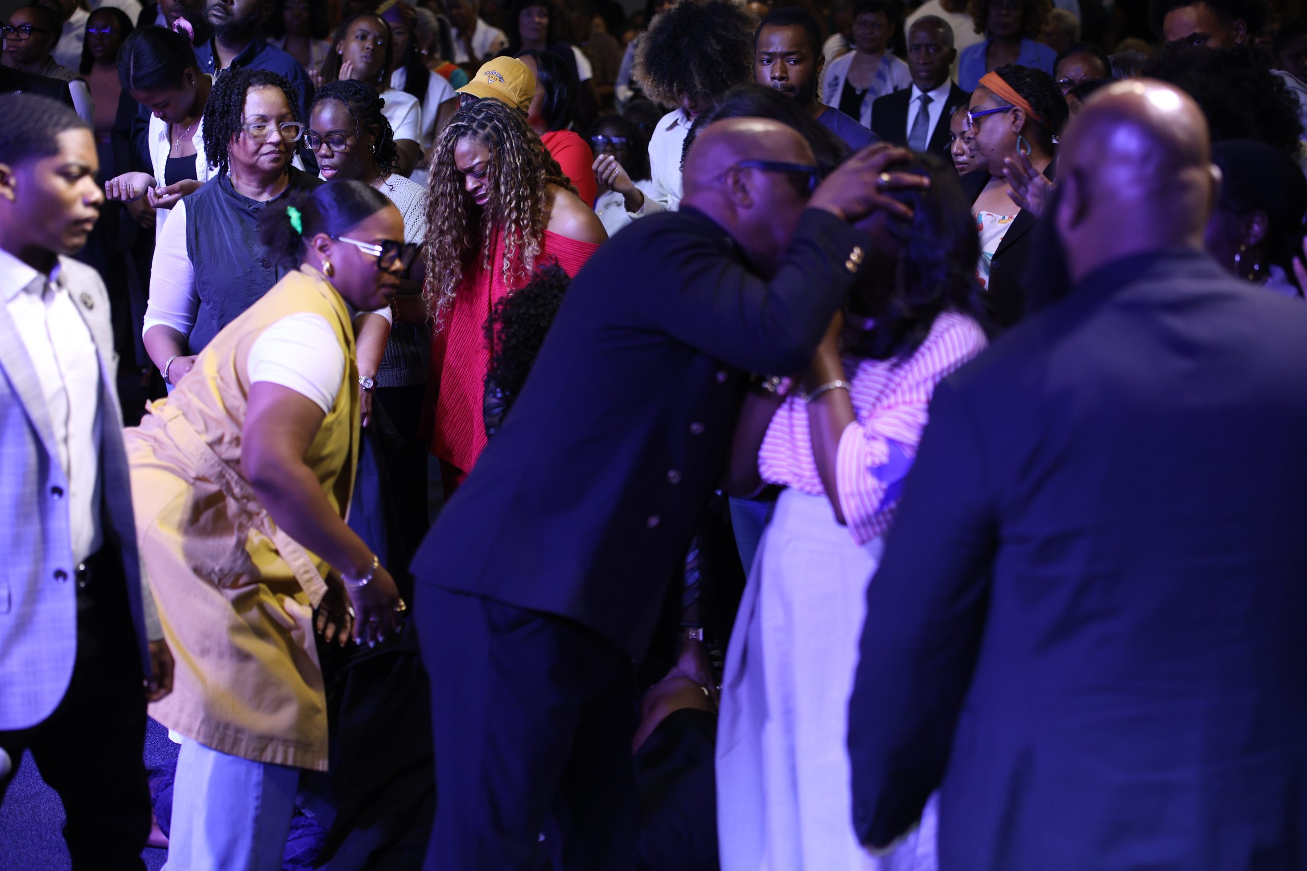 Altar-call ministry — pastors and brothers laying hands in prayer